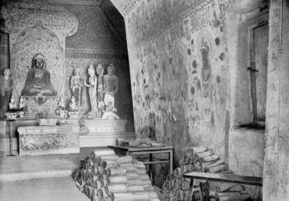 1907 photo showing piled-up manuscripts inside Cave 16 outside the door of the Library Cave